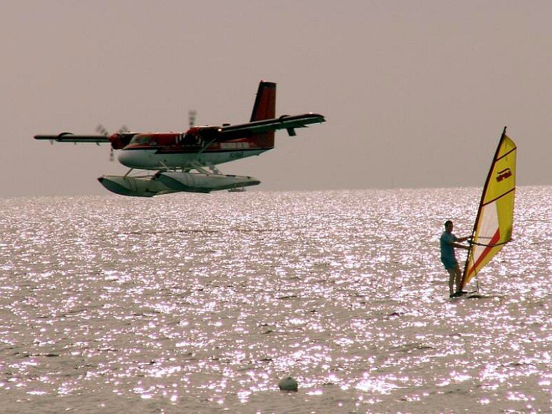 Seaplane and windsurfer on water