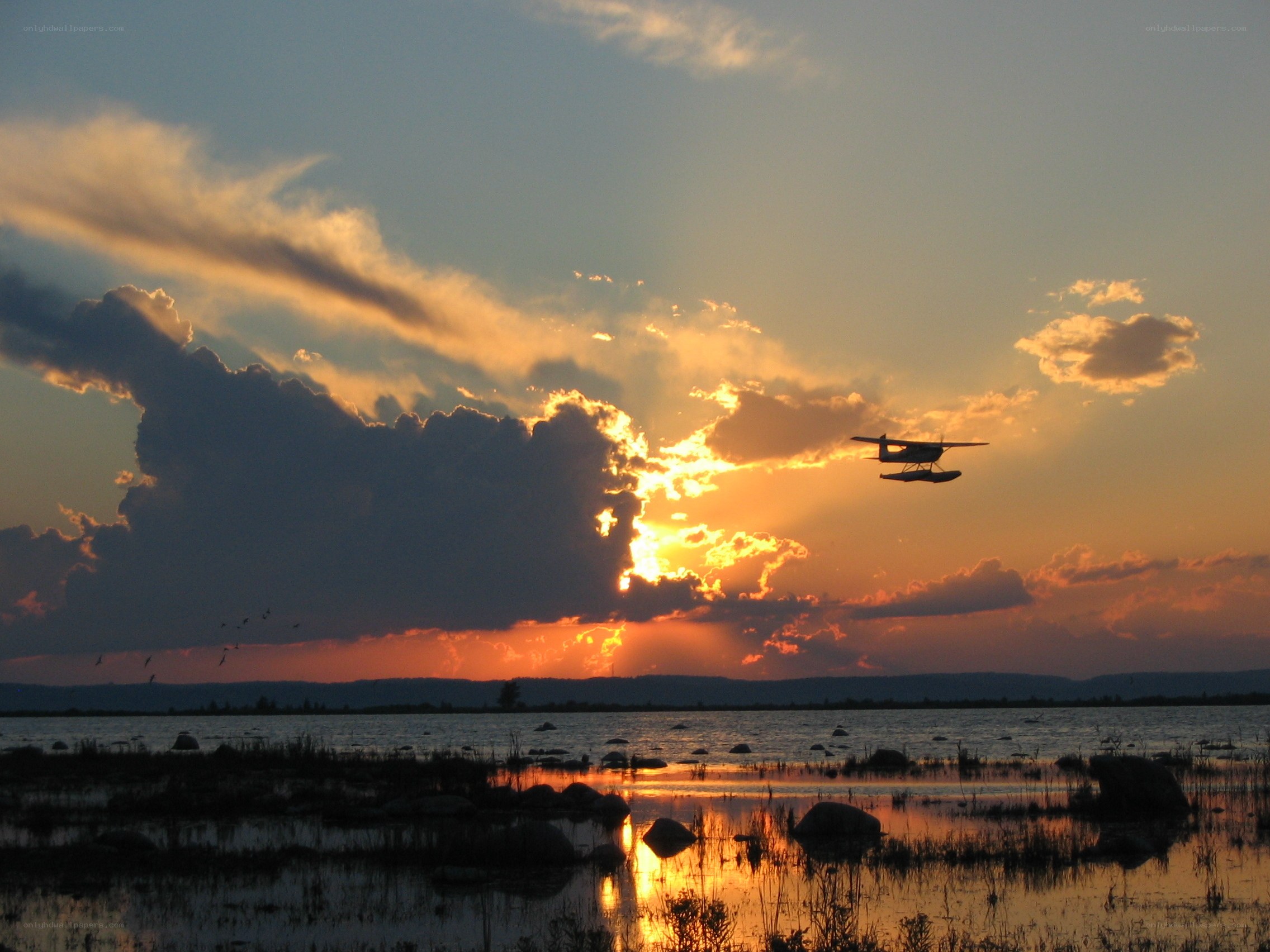 Seaplane at sunset over lake