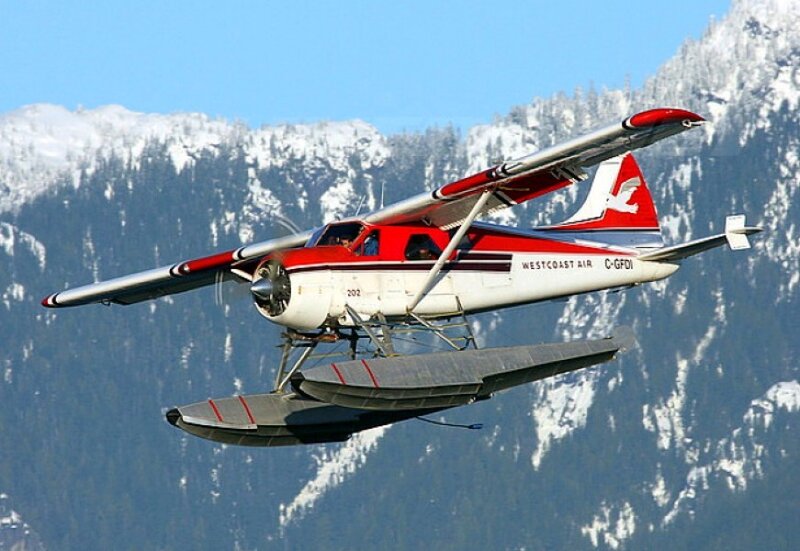Seaplane flying over snowy mountains