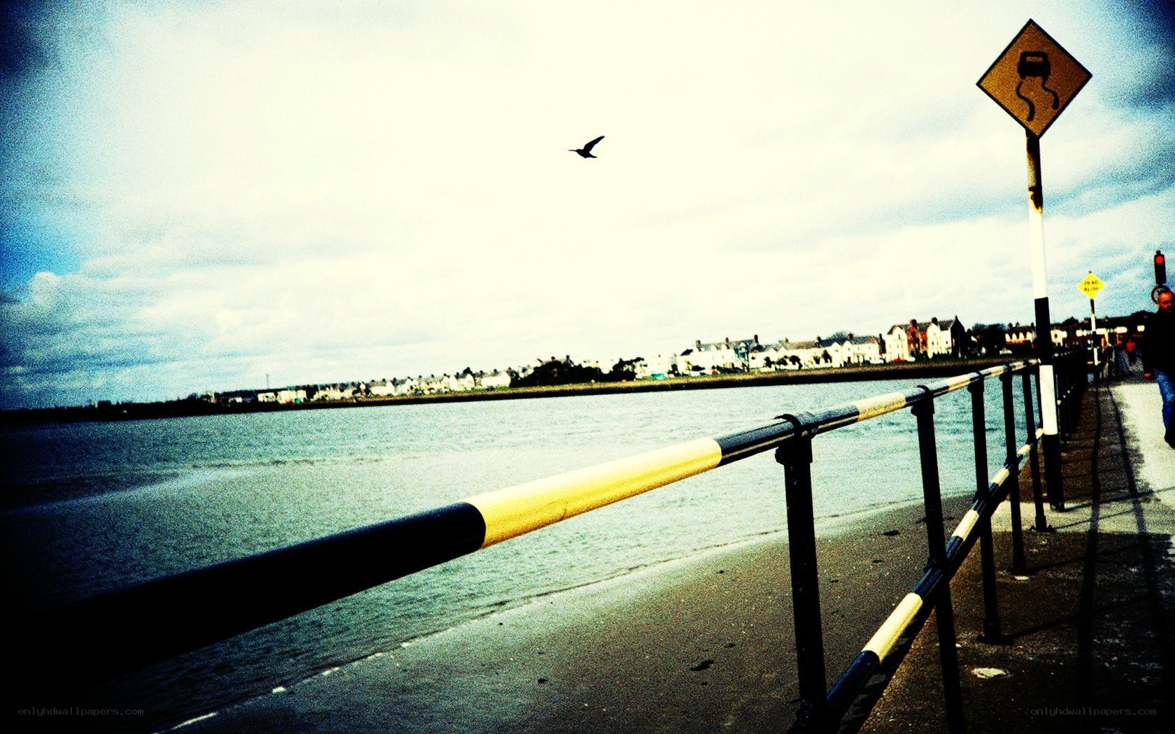 Seaside walkway with warning sign