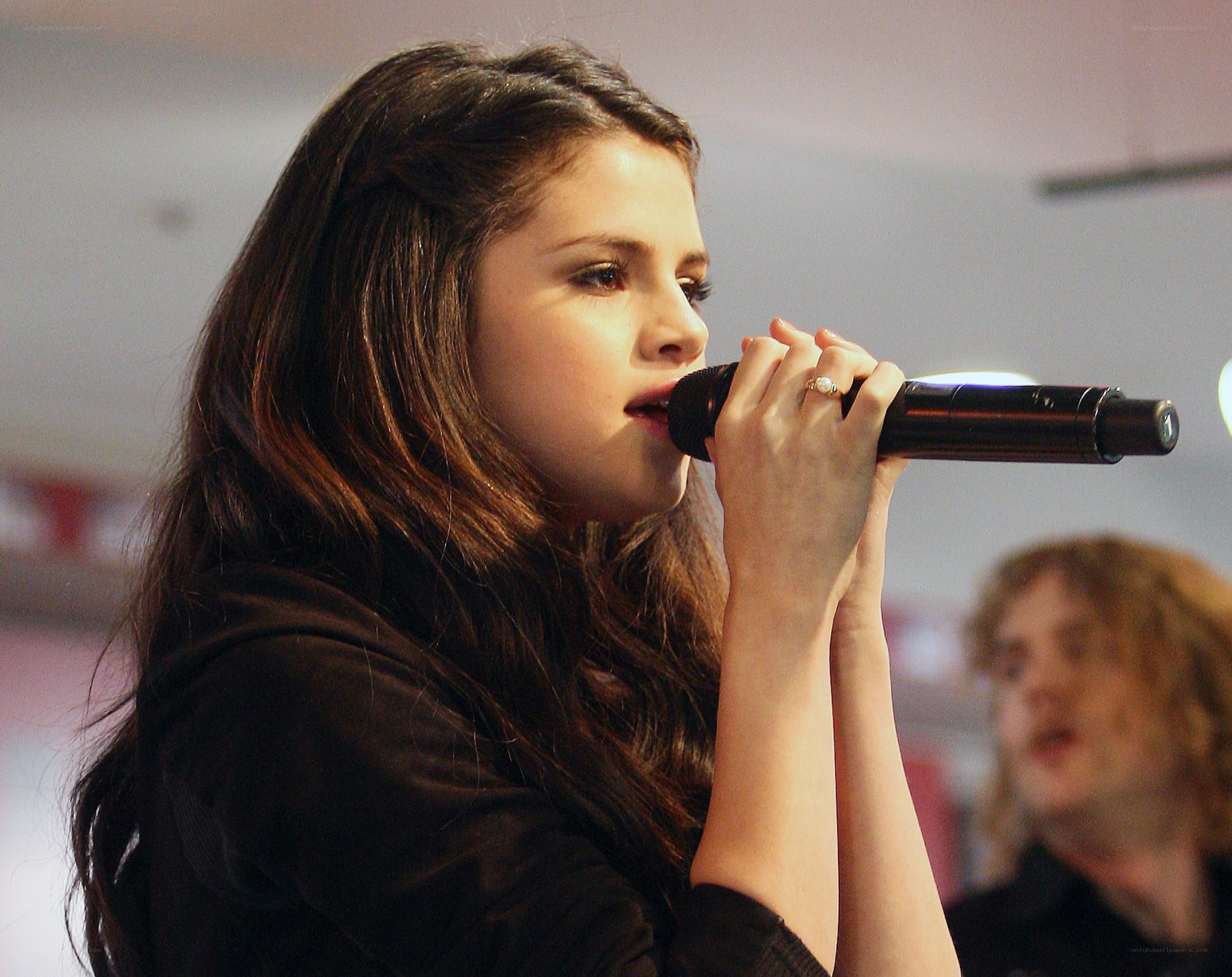 Selena Gomez singing into a microphone