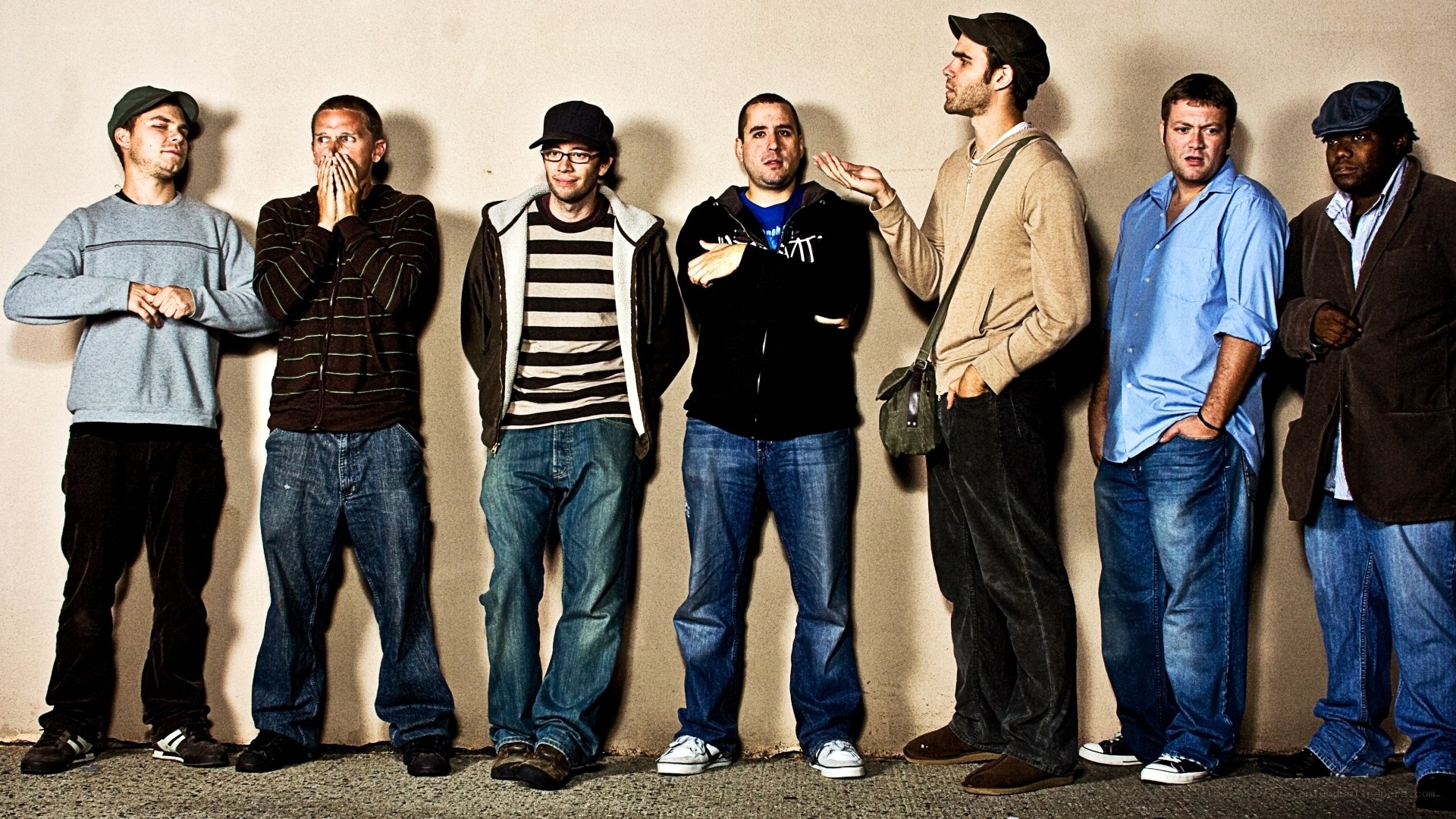 seven men standing against wall
