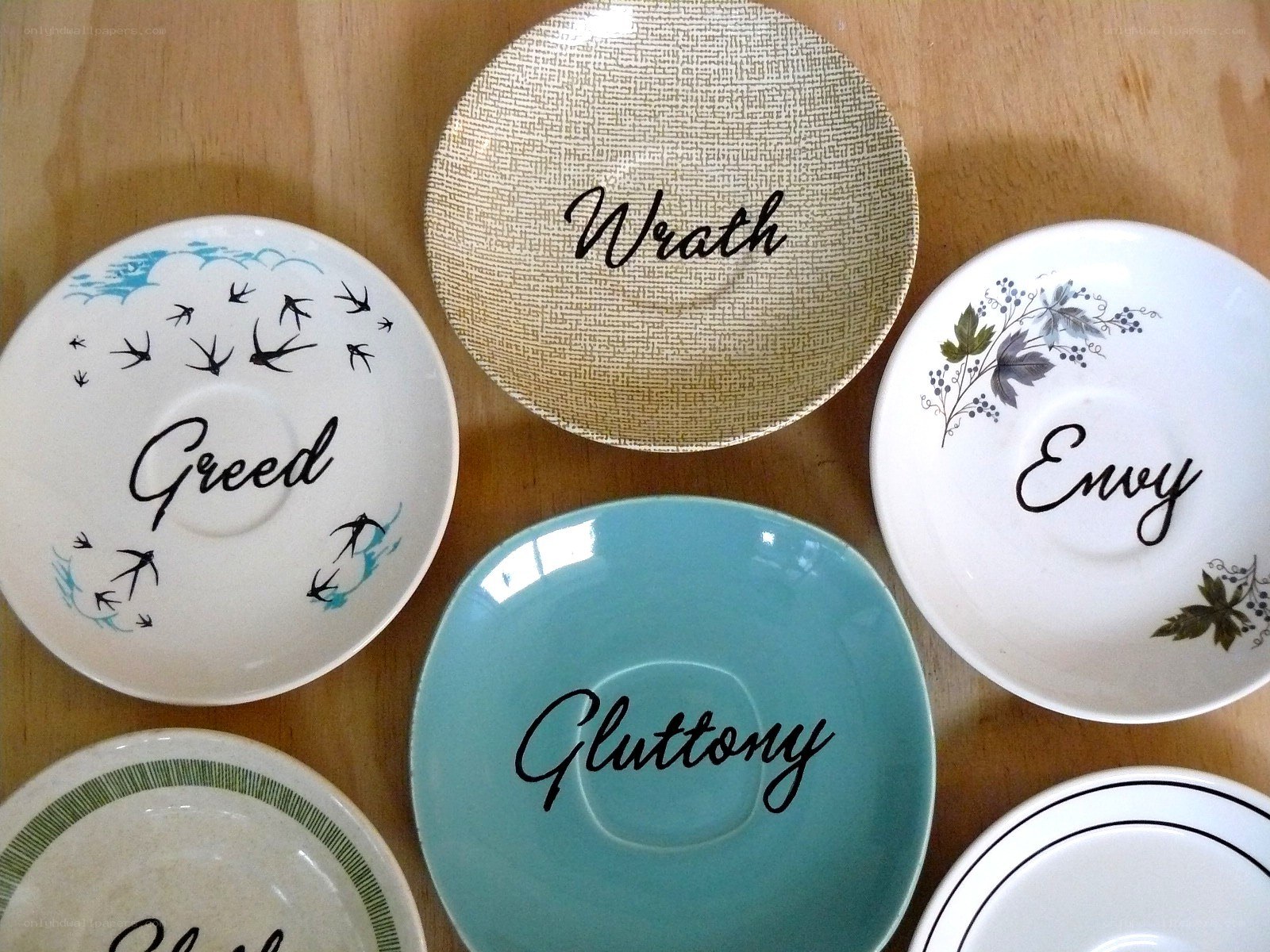 Seven plates with vices written on them