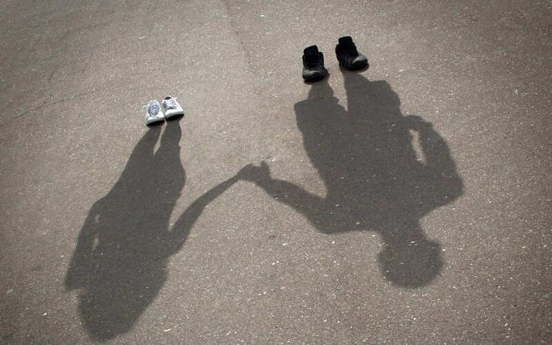 Shadows of two people holding hands