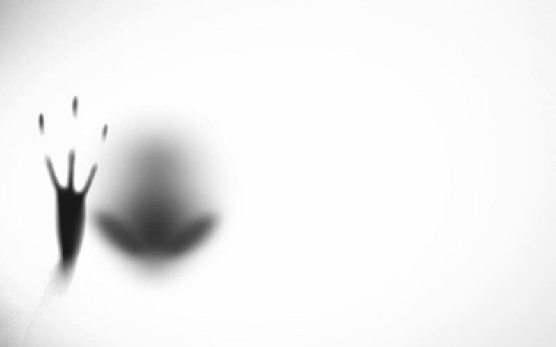 shadowy hand on glass