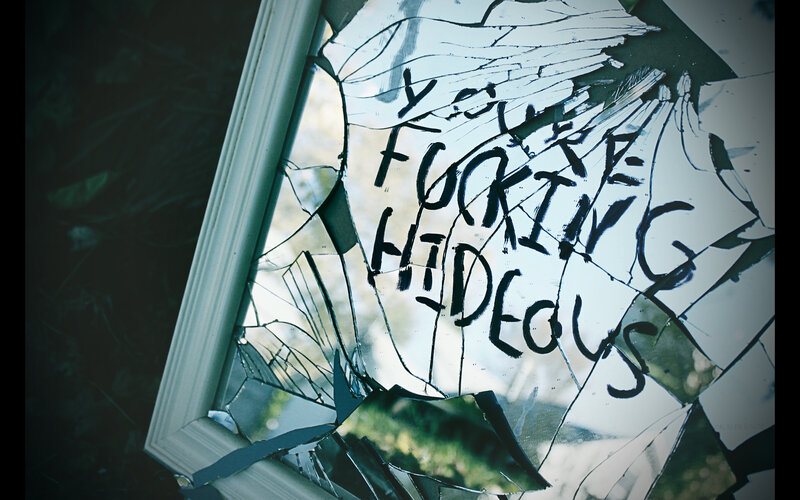 shattered mirror with graffiti