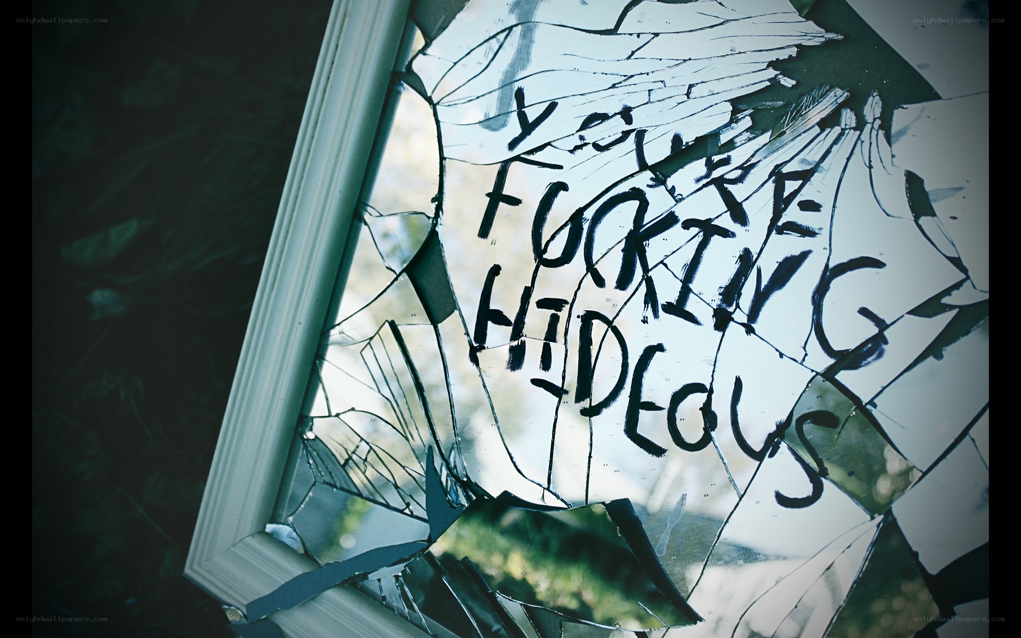 shattered mirror with graffiti