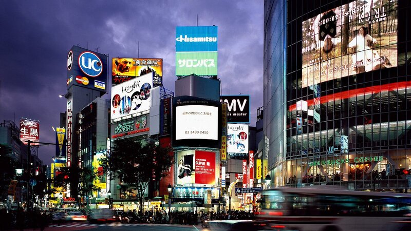 Shibuya at dusk with bright billboards