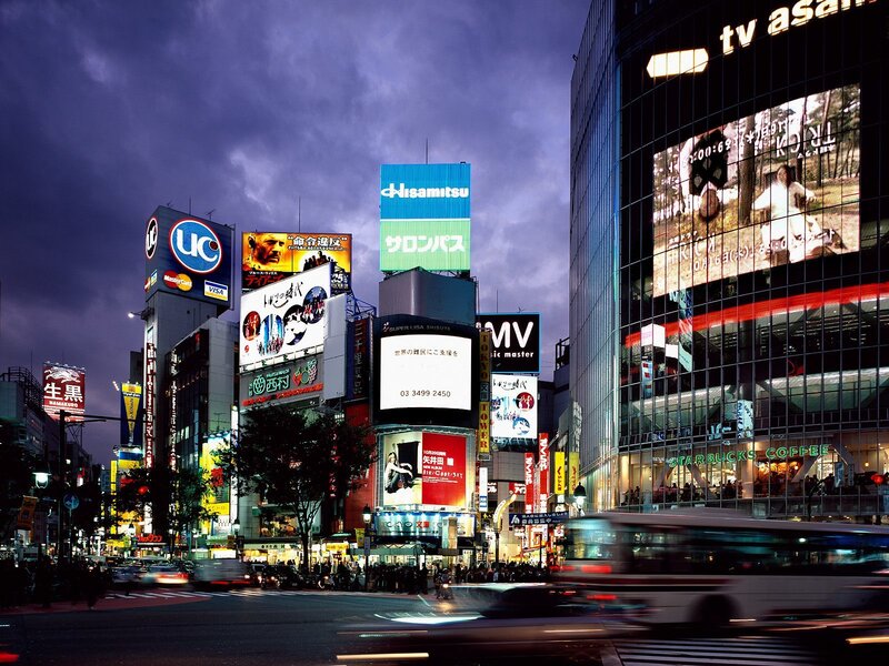 Shibuya at dusk with bright billboards