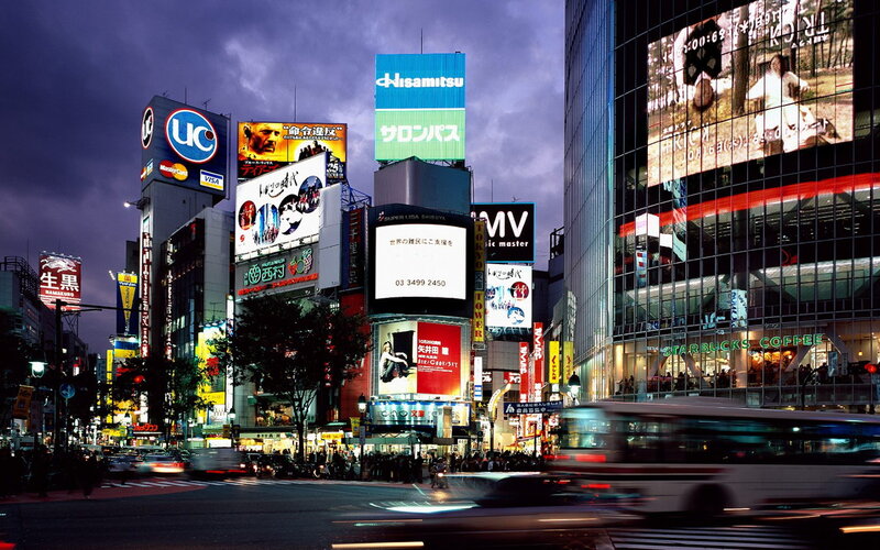 Shibuya at dusk with bright billboards