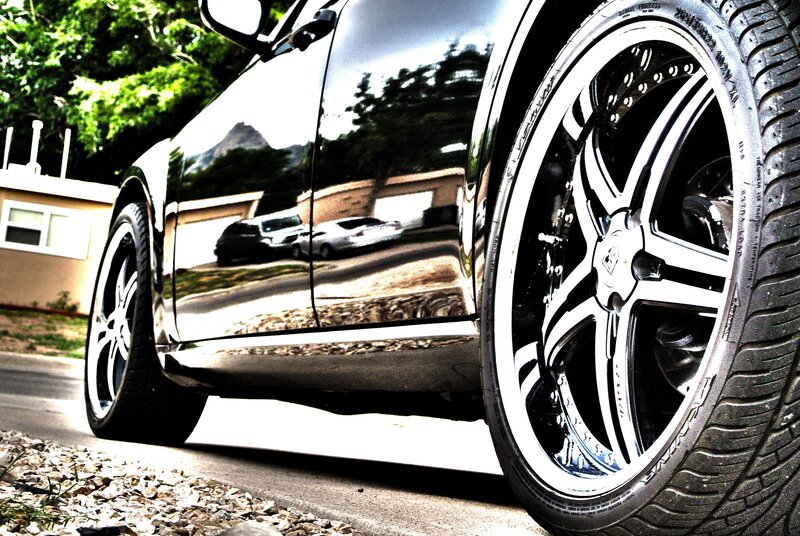 shiny black car with custom wheels