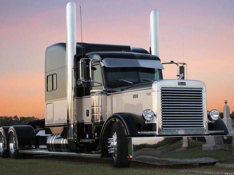shiny black semi-truck at sunset