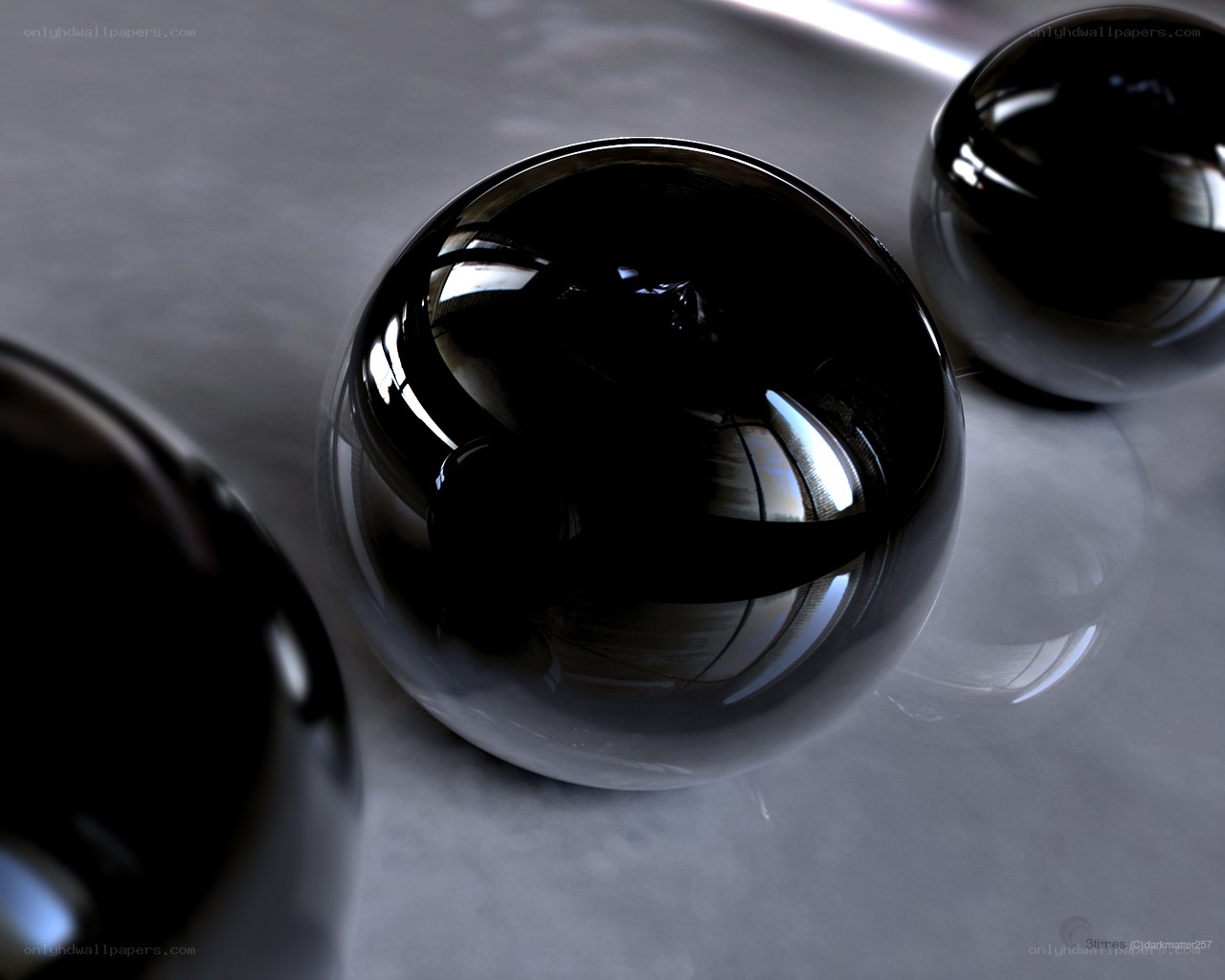 Shiny black spheres on gray surface