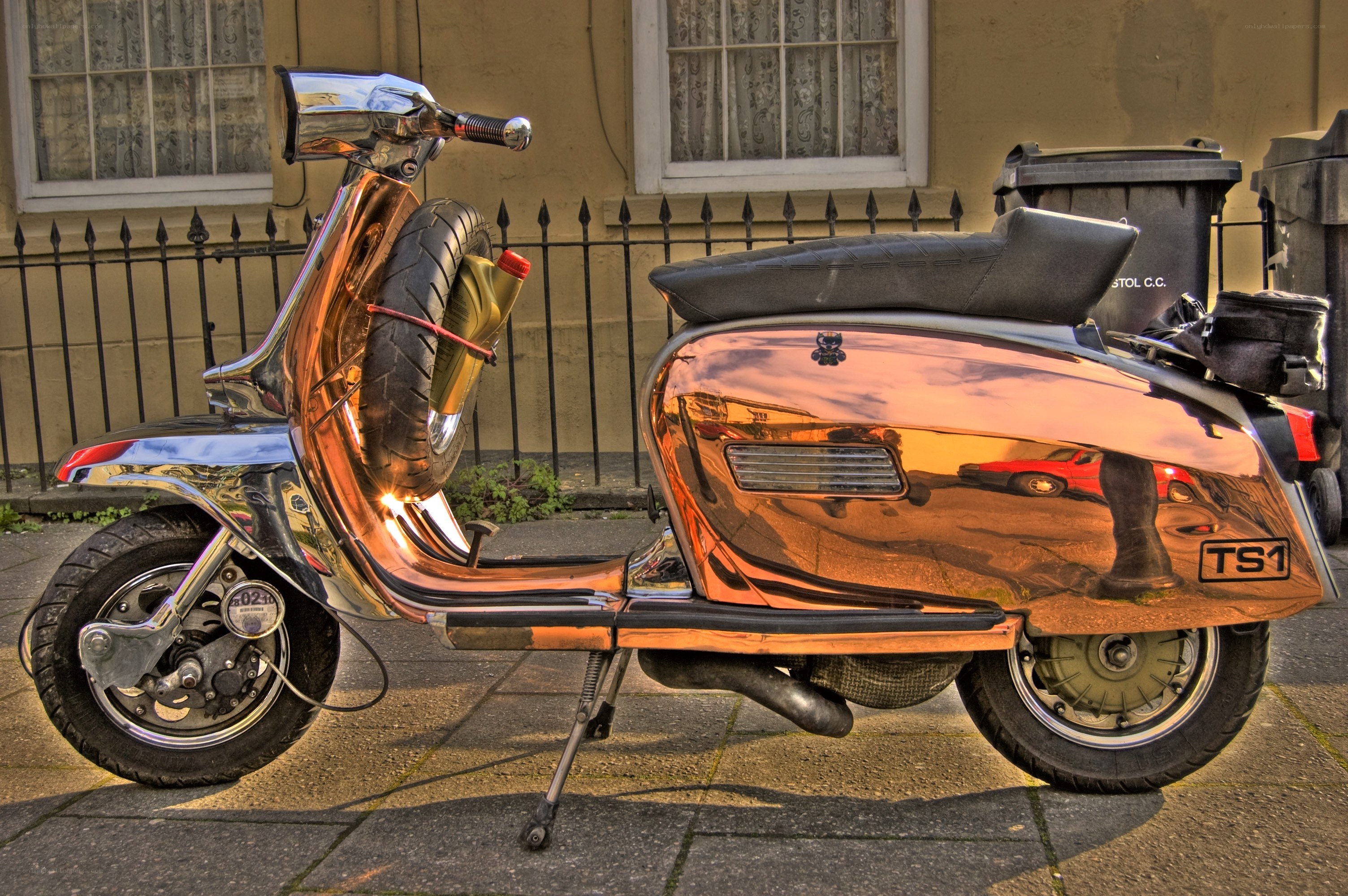 Shiny copper scooter on sidewalk