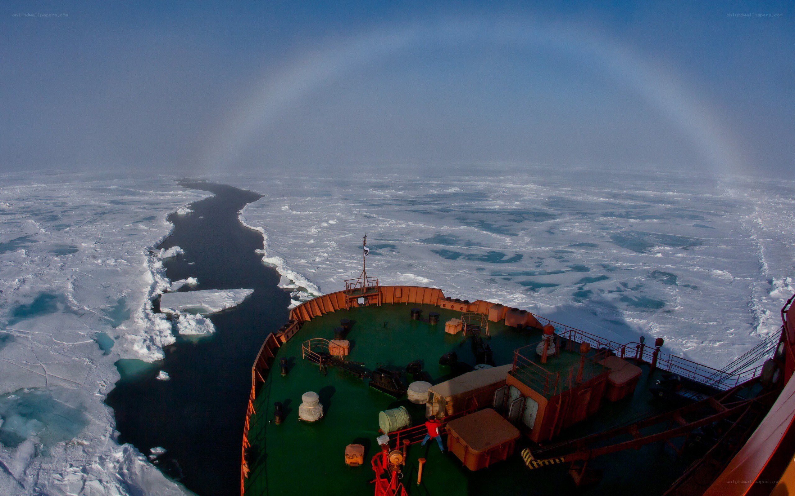 ship in icy waters with rainbow