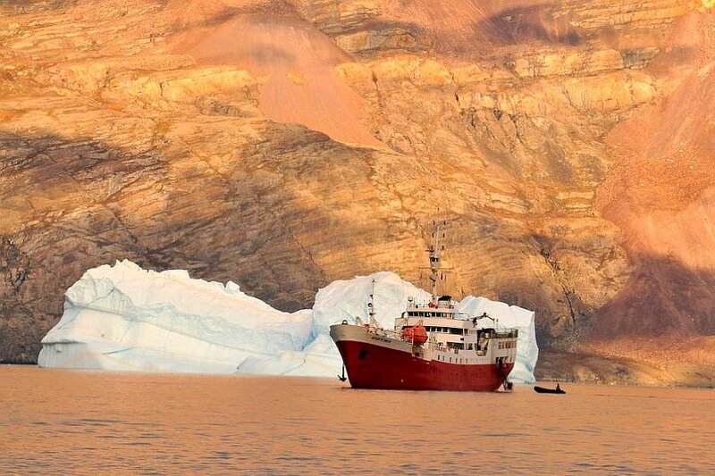 Ship near iceberg in fjord