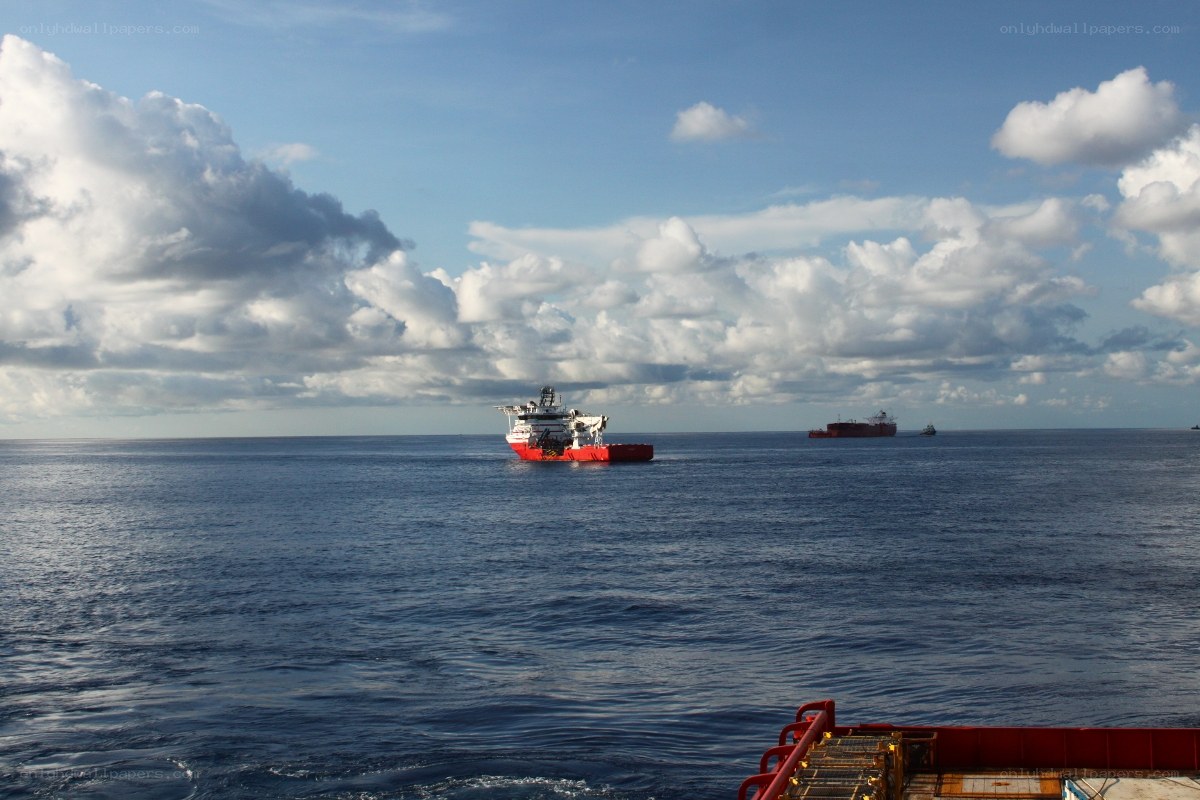 Ships at sea under cloudy sky