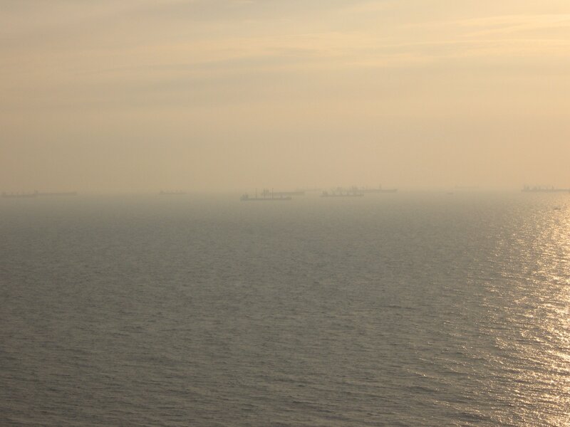 ships in hazy sea at sunset