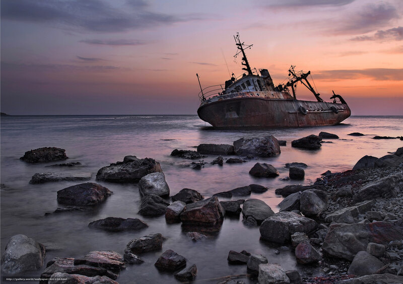 shipwreck at sunset on rocky shore