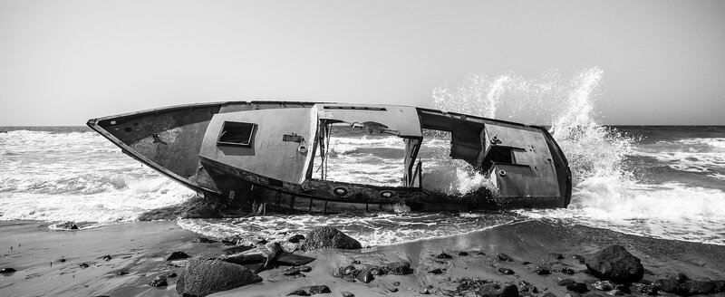 Shipwreck on Beach — Black, Dramatic, Afternoon