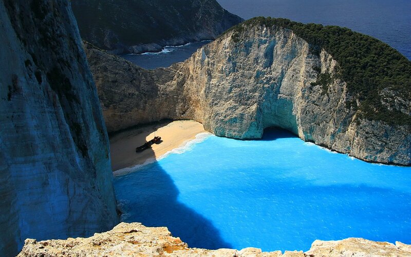 Shipwreck on Beach — Blue, Dramatic, Afternoon, Photograph, Cliffs