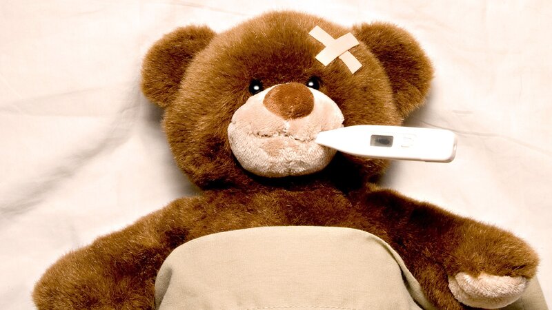 sick teddy bear with thermometer