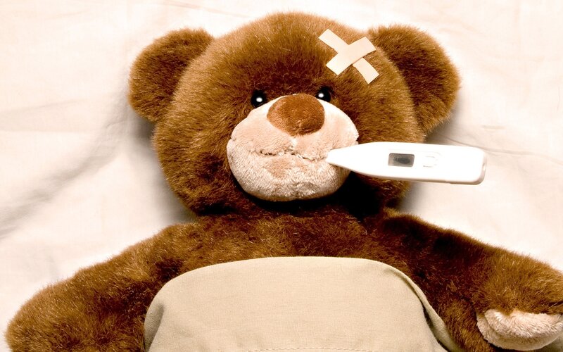 sick teddy bear with thermometer