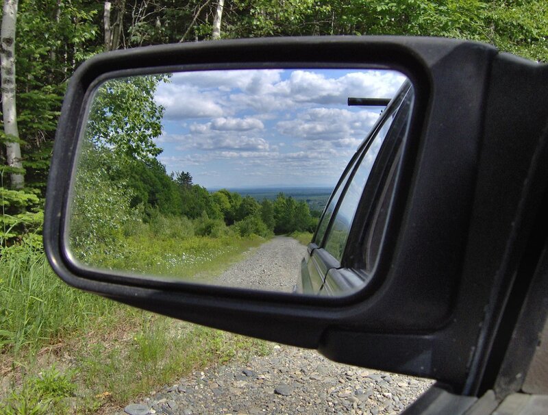 side mirror view of gravel road