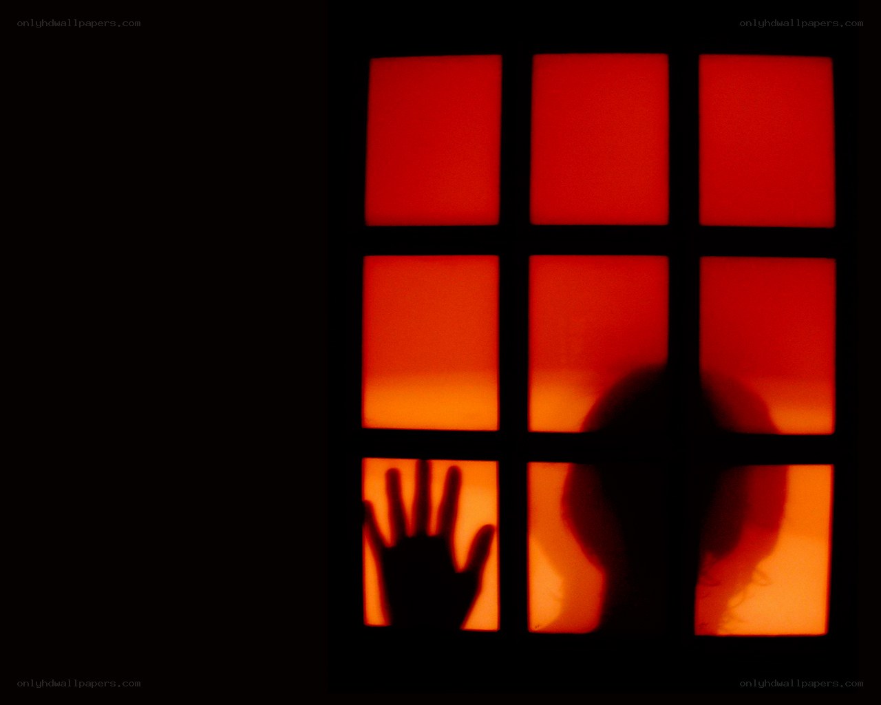 Silhouette at a red-lit window