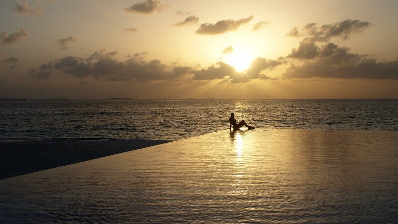 Silhouette at infinity pool sunset