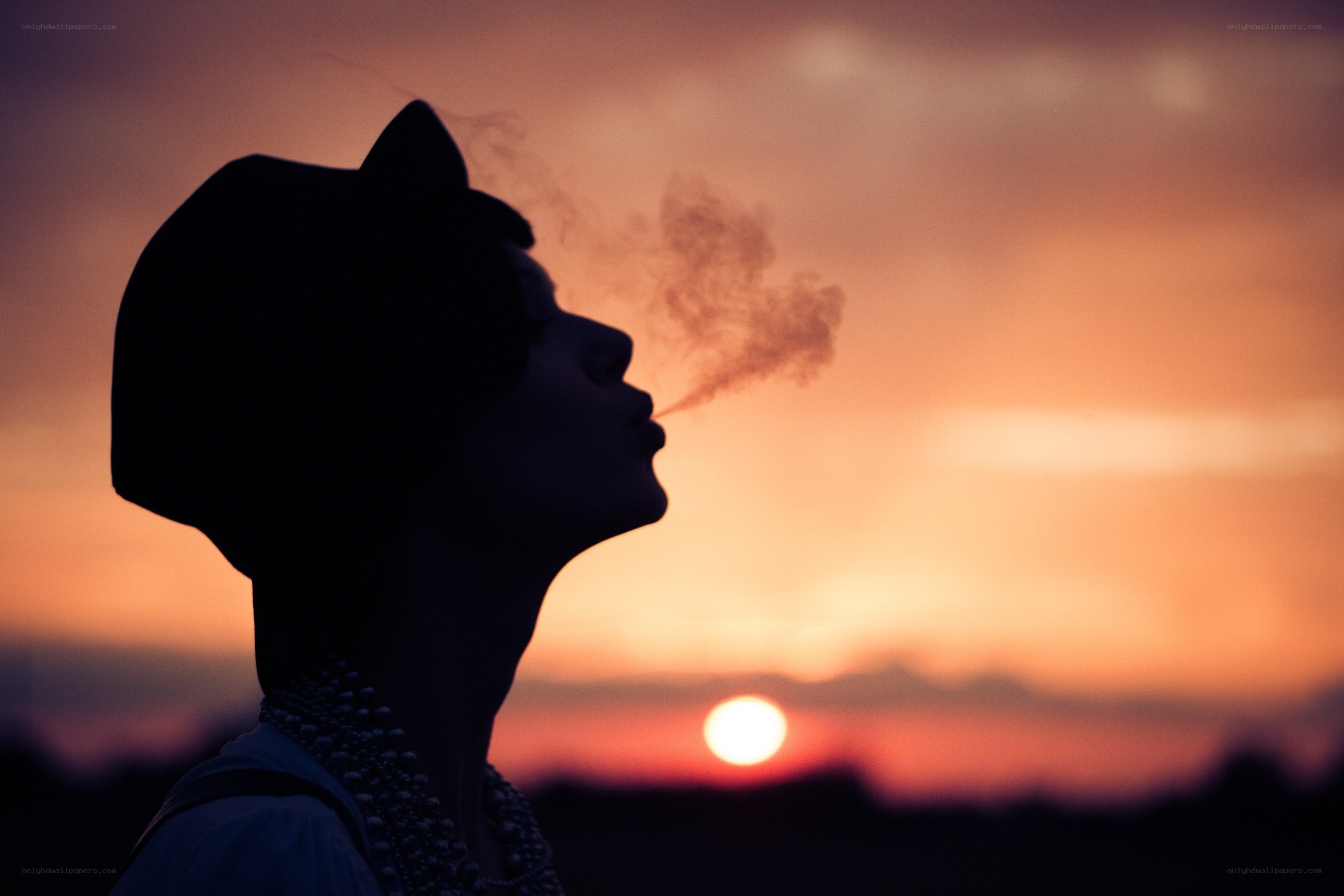silhouette at sunset exhaling smoke