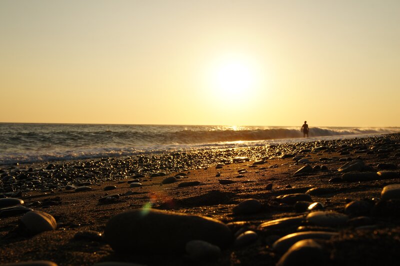 Silhouette at sunset on a pebble beach