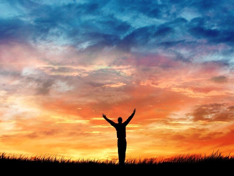 Silhouette at sunset with arms raised