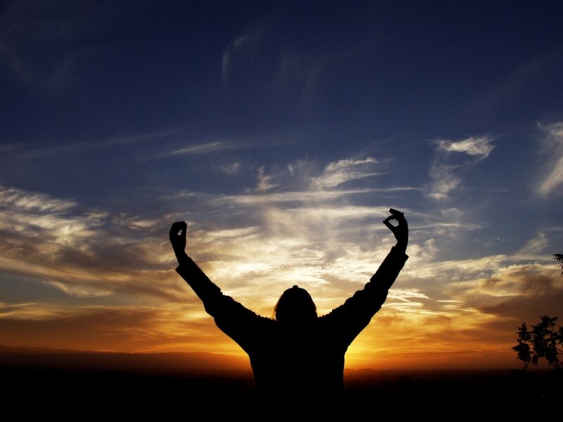 Silhouette at sunset with raised arms