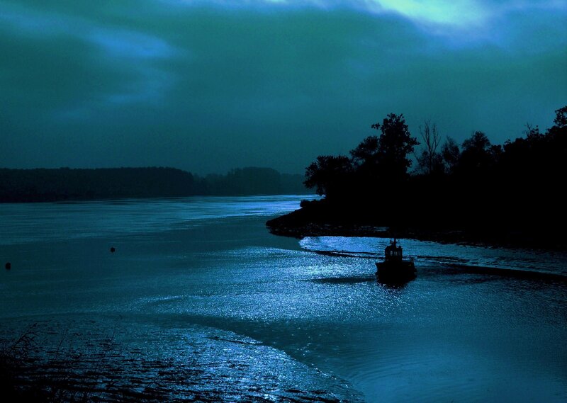 Silhouette boat on river at night