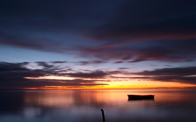 Silhouette Boat on Water — Orange, Serene, Sunset, Photograph, Sky, Blue