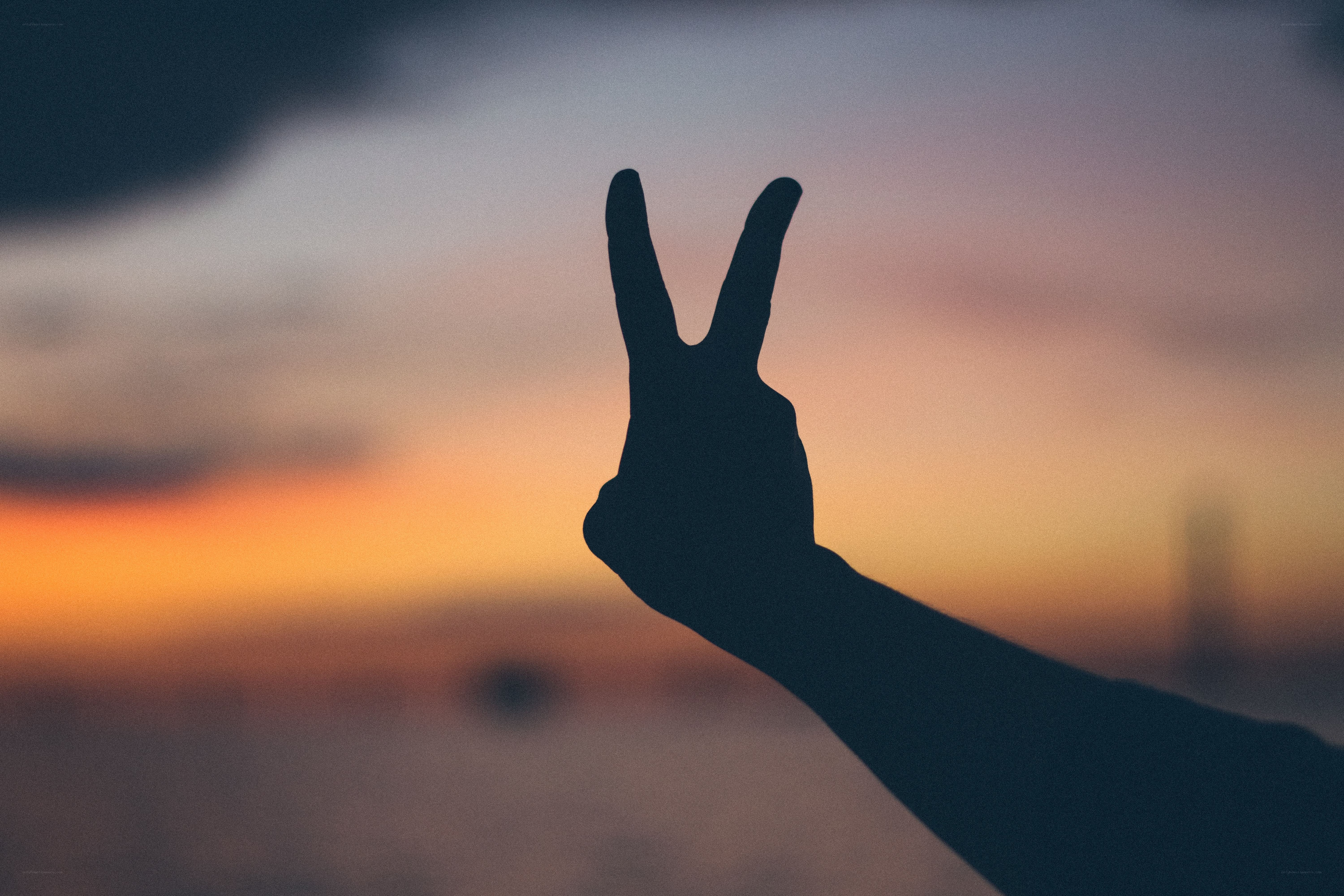 silhouette hand making peace sign