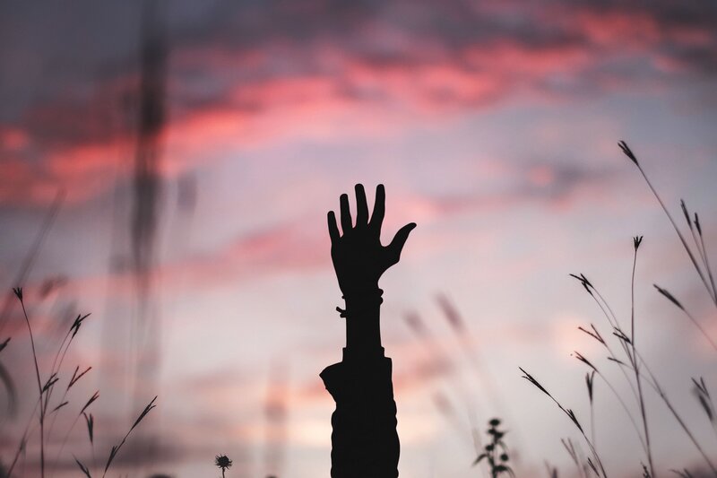 silhouette hand reaching sky