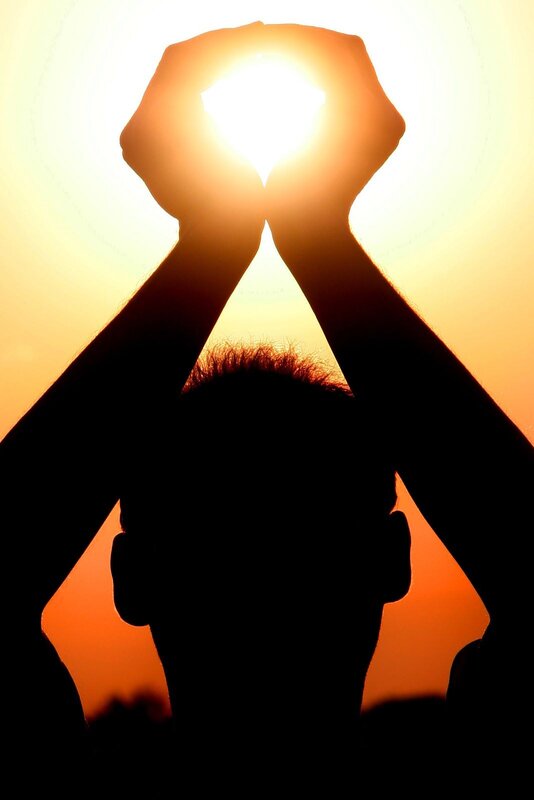 Silhouette holding sun