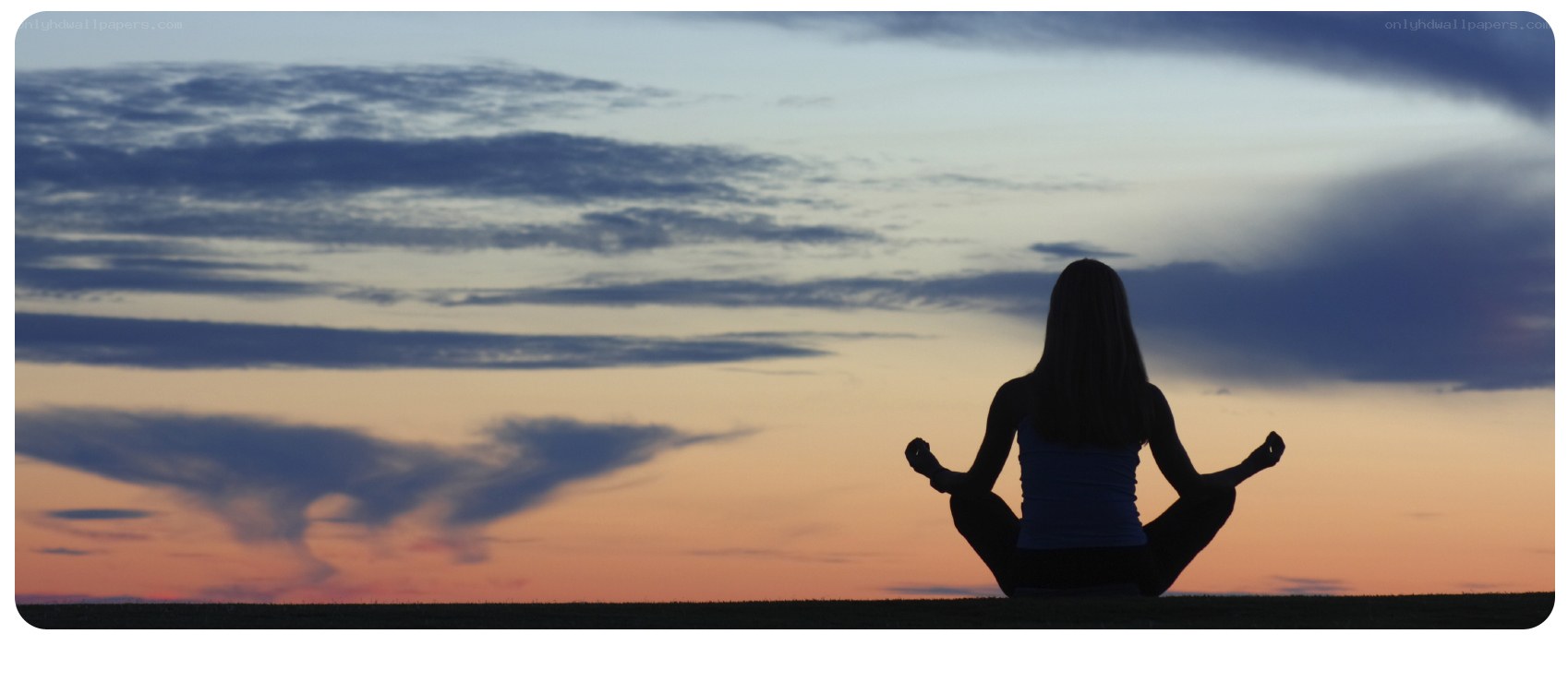 Silhouette meditating at sunset