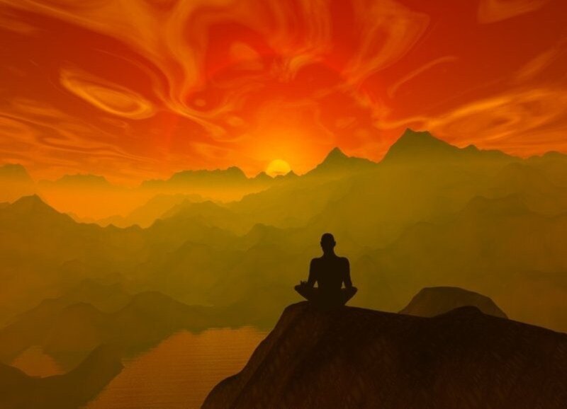 Silhouette Meditating on Cliff