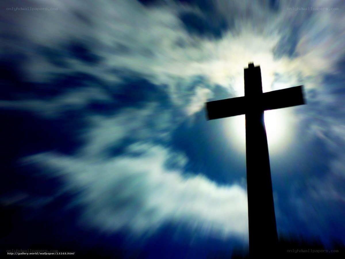 Silhouette of a cross against a cloudy sky