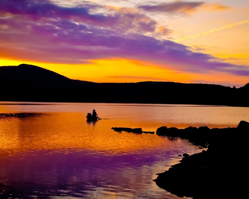 Silhouette of a person in a boat at sunset