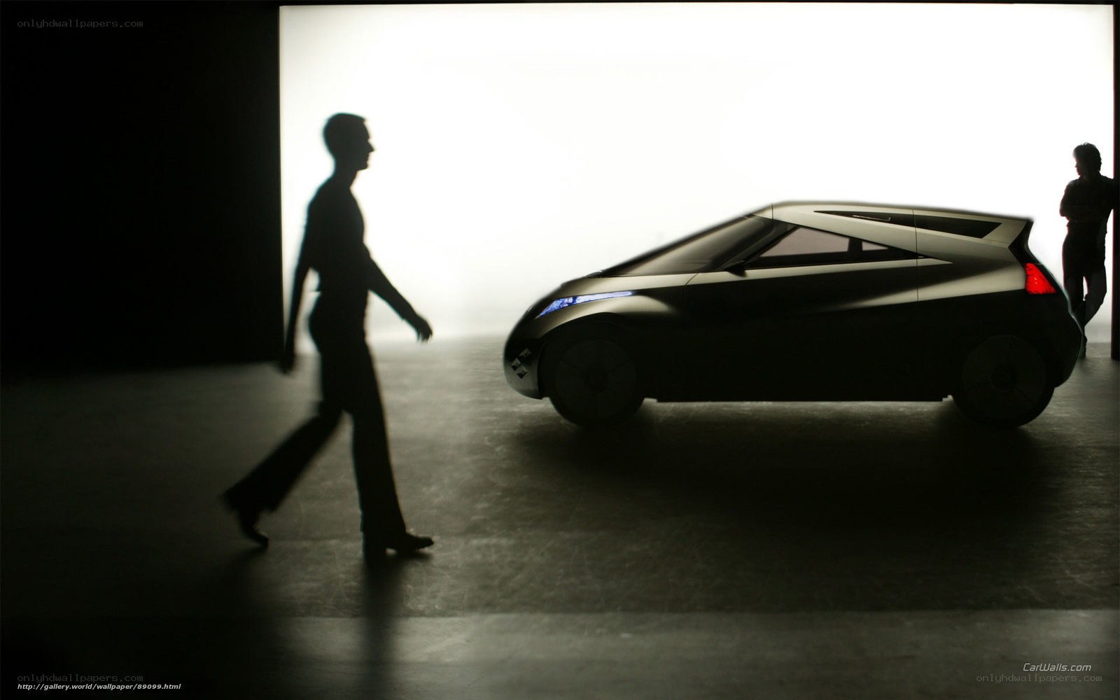 Silhouette of a person walking past a concept car
