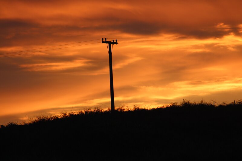 Silhouette of a utility pole at sunset