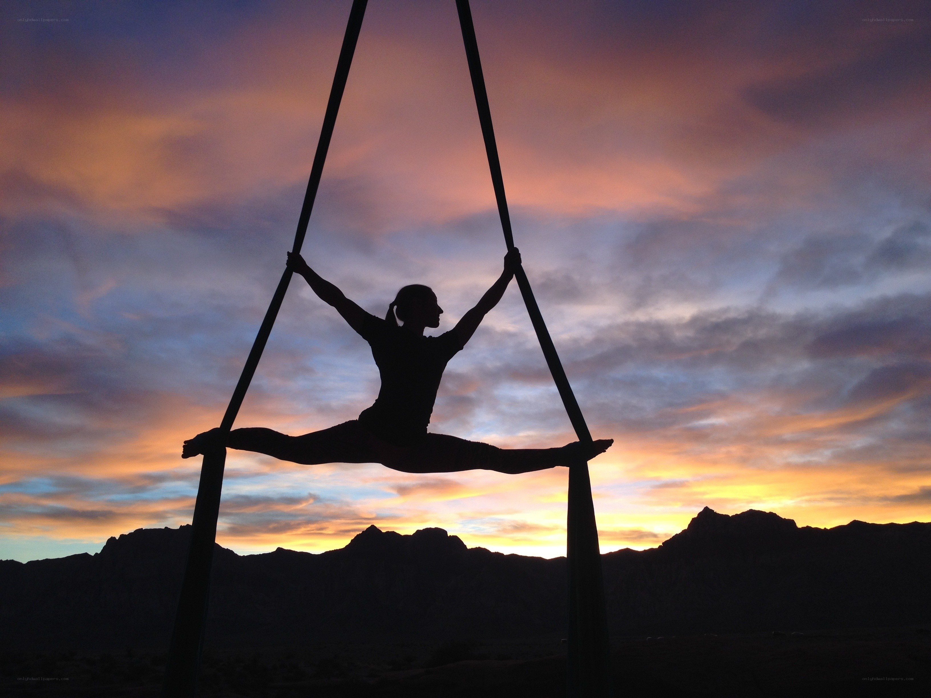 Silhouette of aerialist at sunset