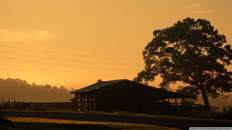 Silhouette of barn at sunrise