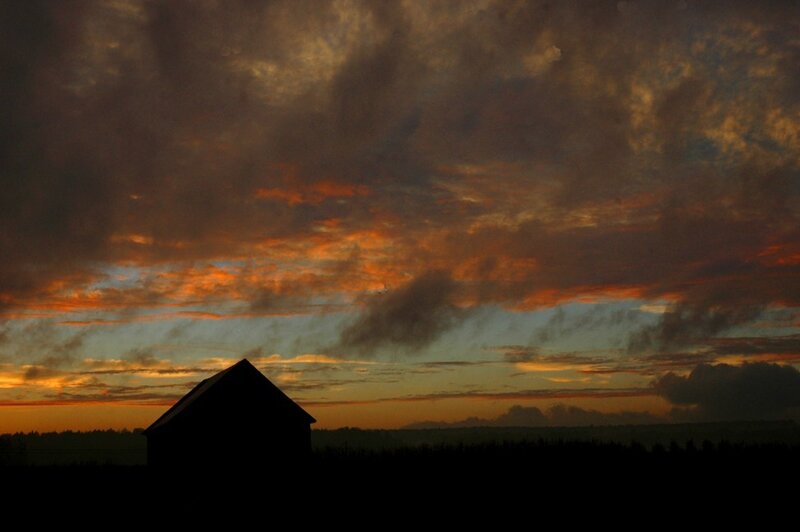 Silhouette of barn at sunset