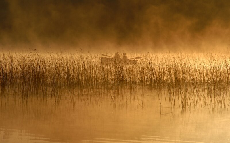 Silhouette of boaters in mist