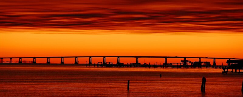 Silhouette of Bridge at Sunset — Orange, Dramatic, Photograph, Water, Sky, Red